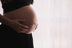 woman holding her pregnant belly, new blog from Evoke Wilmington, NC